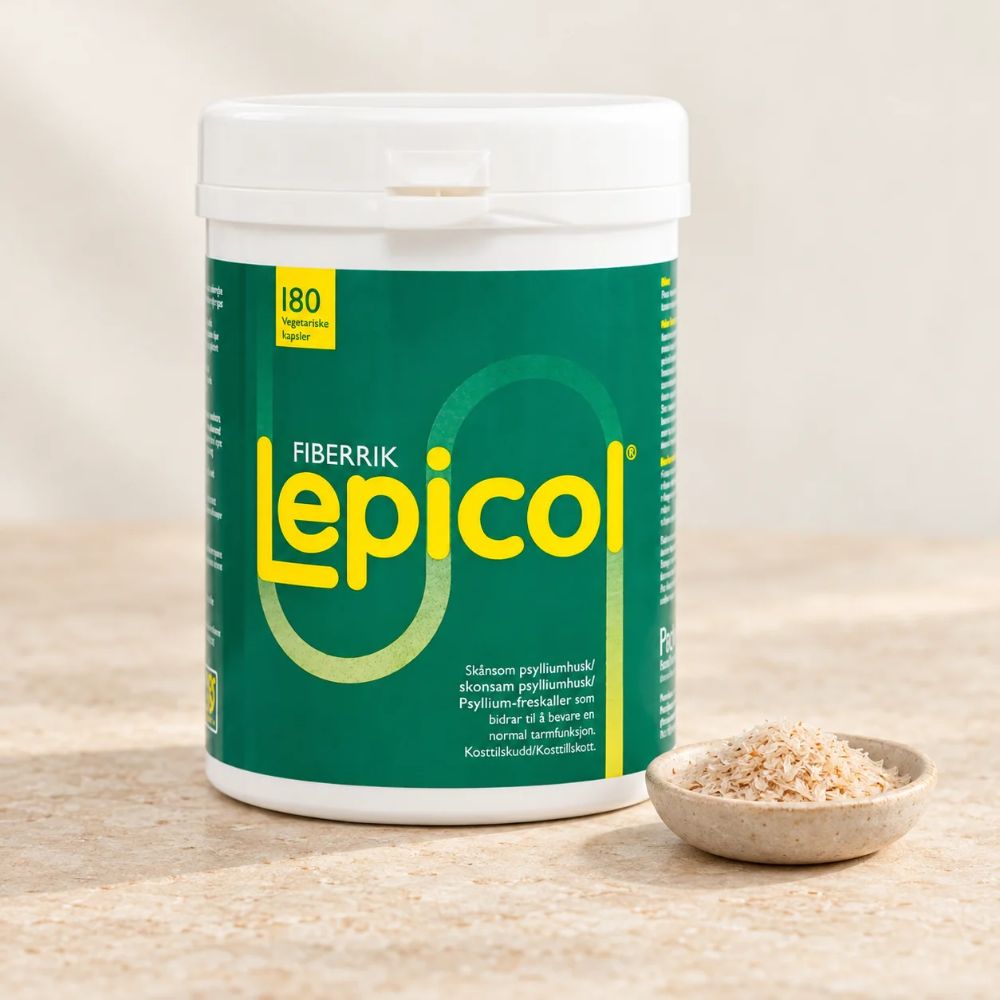 Lepicol 180 vegetariske kapsler på en lys steinbenk med en liten skål psylliumfrøskall ved siden av.