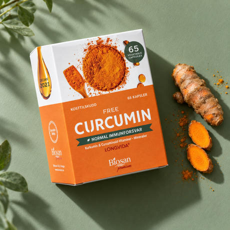 Biosan Free Curcumin 65 kapsler på en grønn bakgrunn med fersk gurkemeierot og gurkemeieskiver.