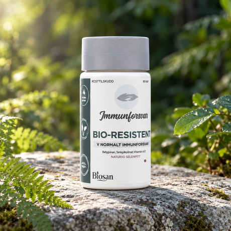 Biosan Bio-Resistent på en naturstein omgitt av grønne blader og bregner i mykt morgenlys.