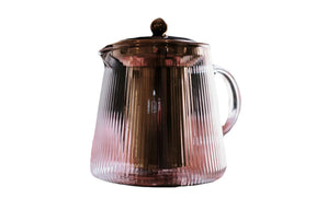 Elegant tekanne i borosilikatglass med kobberdetaljer og klart design