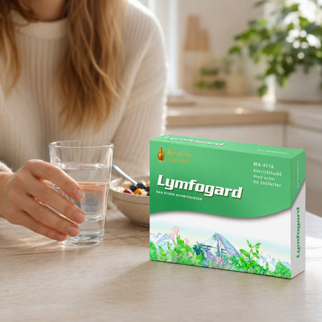 lymogard kosttilskudd med urter og 60 tabletter ved siden av et glass vann under frokosten